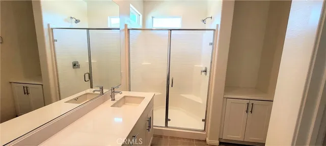 a bathroom with a sink mirror and shower