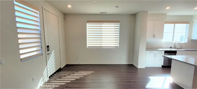 a view of a kitchen from the hallway with a window