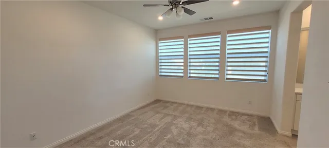 an empty room with a window and a fan