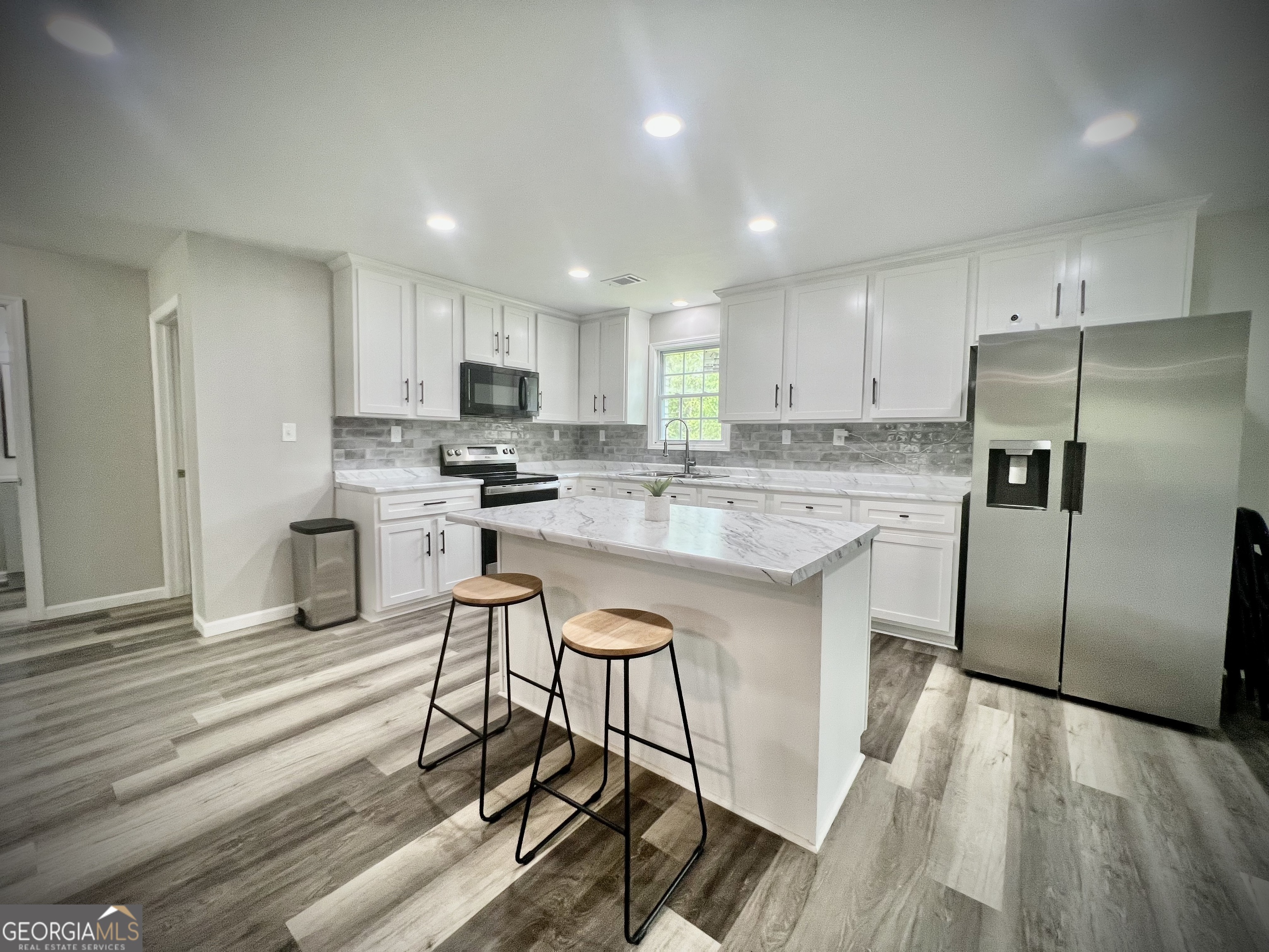 1962 Anderson Road Rentz, GA 31075 - Photo 11 of 26 a kitchen with stainless steel appliances granite countertop a stove a sink a refrigerator and white cabinets with wooden floor