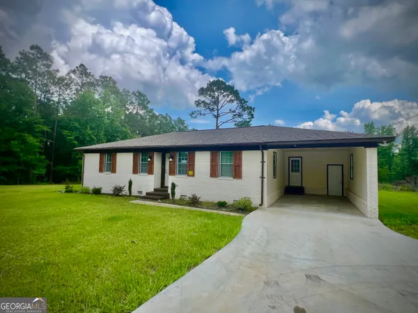 a front view of a house with a garden and yard
