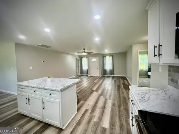 a spacious bathroom with a granite countertop sink a vanity and mirror