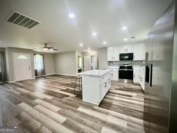 a view of kitchen with sink microwave and refrigerator