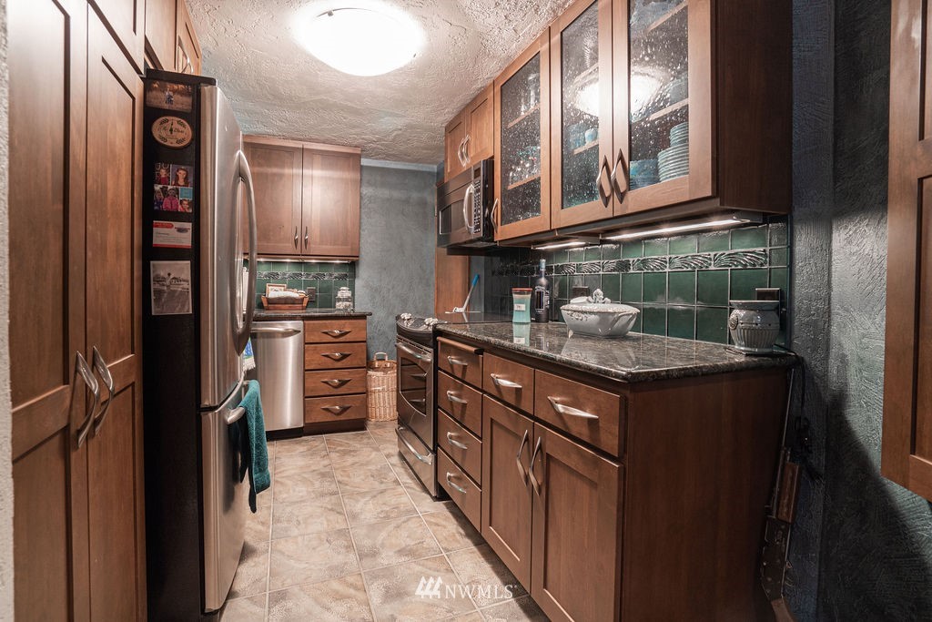 841 South Taylor Road Othello, WA 99344 - Photo 29 of 40 a kitchen with stainless steel appliances granite countertop a stove and cabinets