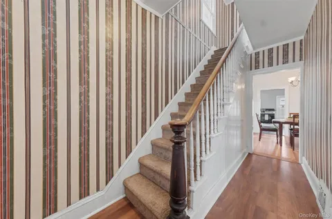a view of a hallway with wooden floor and staircase