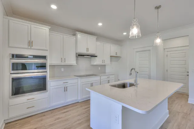 a kitchen with kitchen island a sink appliances and cabinets