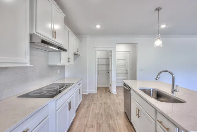 a kitchen with stainless steel appliances granite countertop a sink stove and cabinets