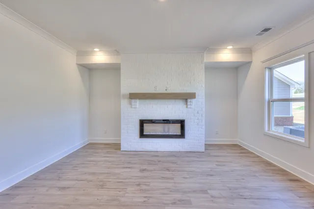 a view of an empty room with a fireplace and a window
