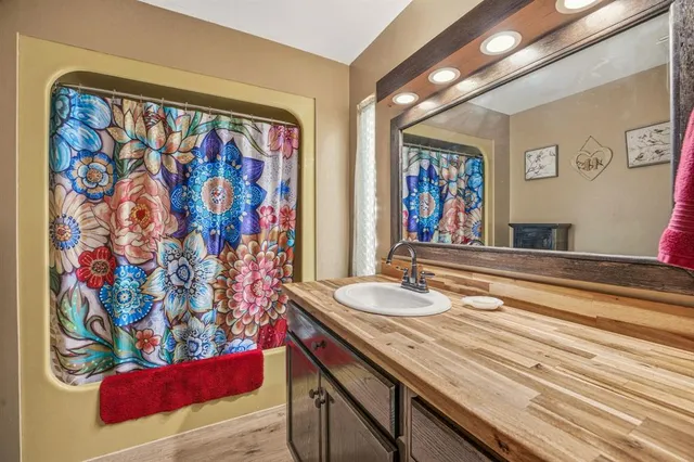a bathroom with a granite countertop sink and a mirror
