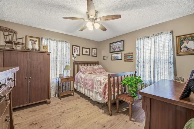 a bedroom with a bed table chair and a window