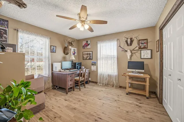 a workspace with wooden floor and windows