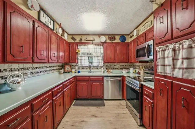 a kitchen with stainless steel appliances granite countertop wooden cabinets a stove top oven a sink and dishwasher