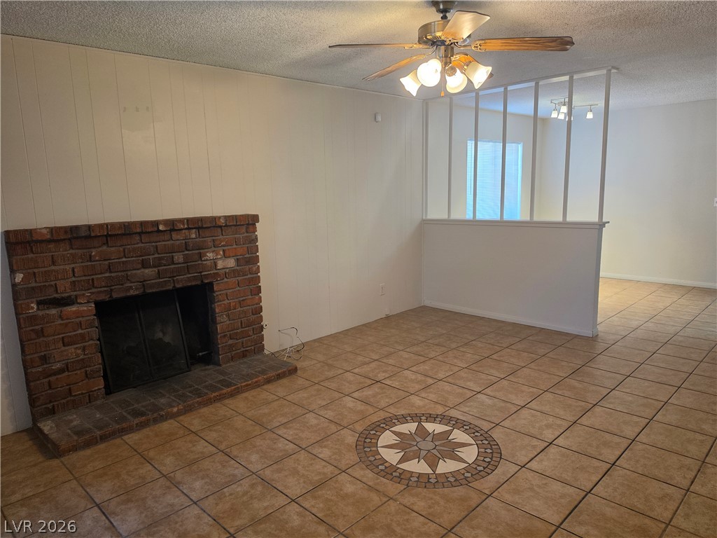 5289 Reeder Circle Las Vegas, NV 89119 - Photo 14 of 40 Tiled floors and a brick fireplace create a cozy atmosphere in this open living space.