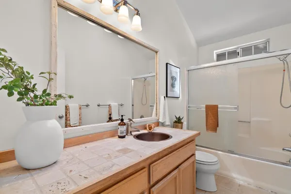 a bathroom with a sink a toilet and shower