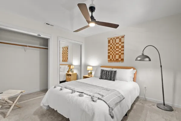 a bedroom with a large bed and a chandelier