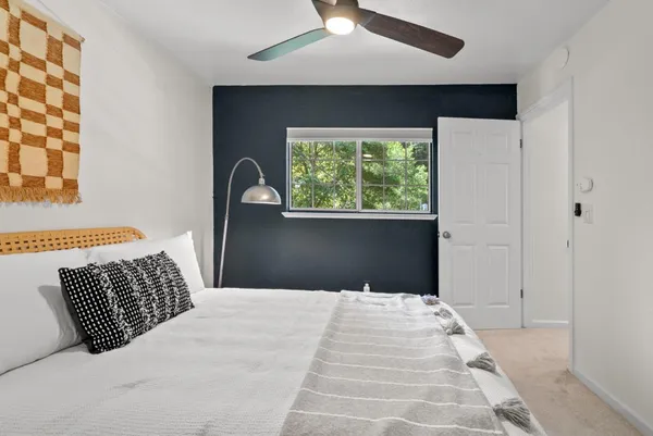 a bedroom with a bed and a large window