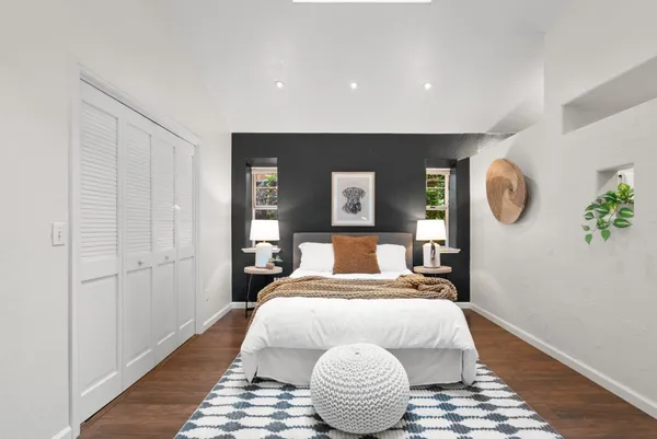 a bedroom with a bed and painting on the wall