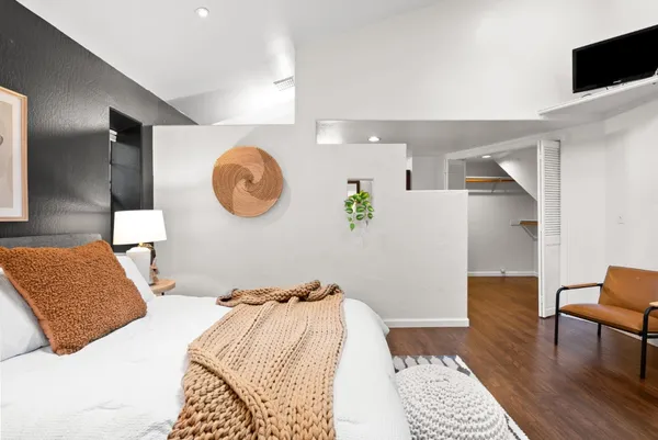 a bedroom with a bed and a lamp with the wooden floor