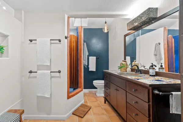 a spacious bathroom with a granite countertop sink and a mirror