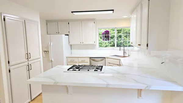 a kitchen with a refrigerator a stove a sink and a window