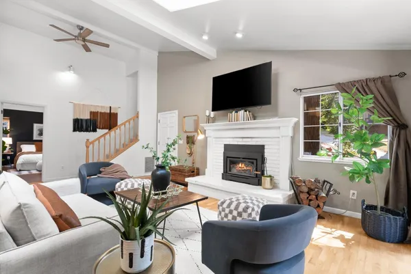 a living room with furniture a flat screen tv and a fireplace
