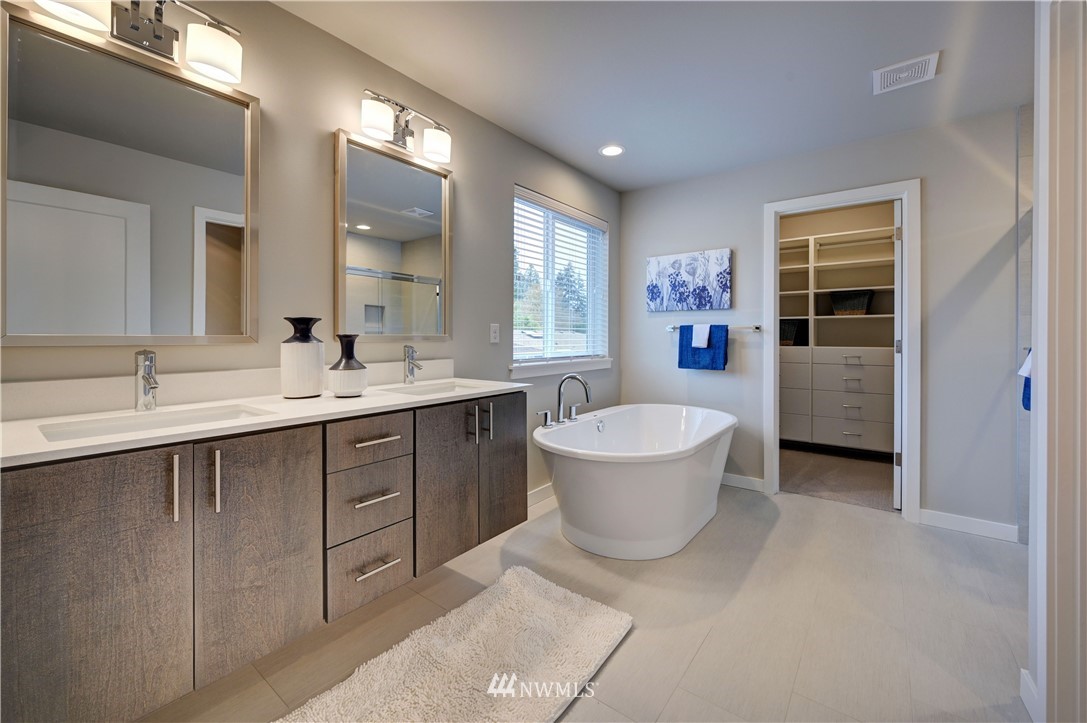 8609 244th Street Southwest, Unit 6 Edmonds, WA 98026 - Photo 11 of 27 a spacious bathroom with a double vanity sink a large mirror and a bathtub