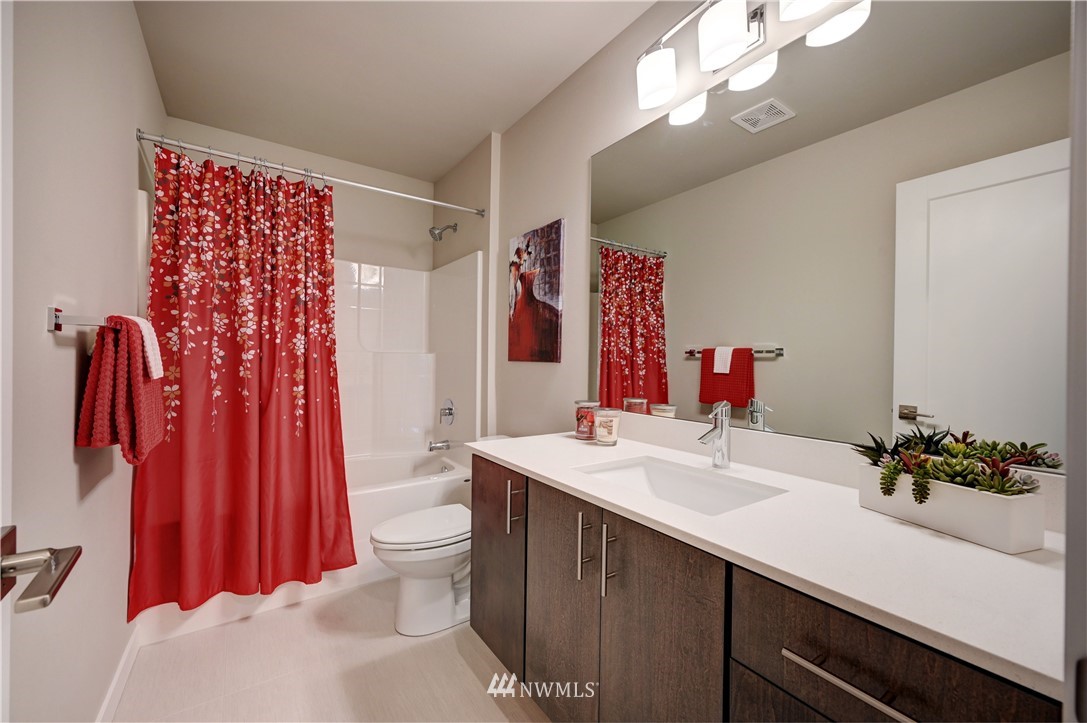 8609 244th Street Southwest, Unit 6 Edmonds, WA 98026 - Photo 19 of 27 a bathroom with a sink a toilet and shower curtain