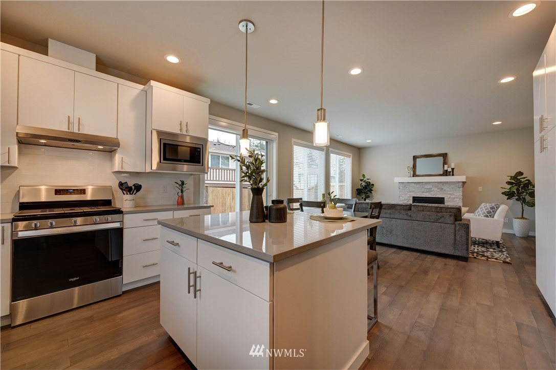 8609 244th Street Southwest, Unit 6 Edmonds, WA 98026 - Photo 5 of 27 a kitchen with kitchen island a white counter top space a stove and cabinets