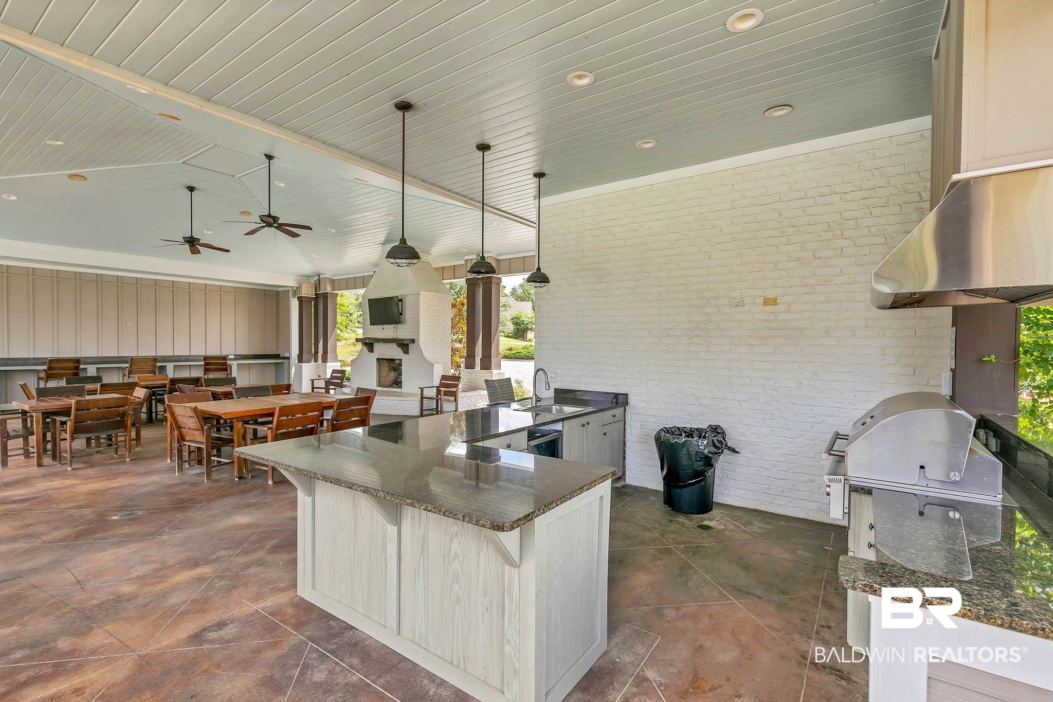 12132 Exbury Way Daphne, AL 36527 - Photo 41 of 47 Kitchen with a kitchen bar, a ceiling fan, wooden ceiling, ventilation hood, and a fireplace