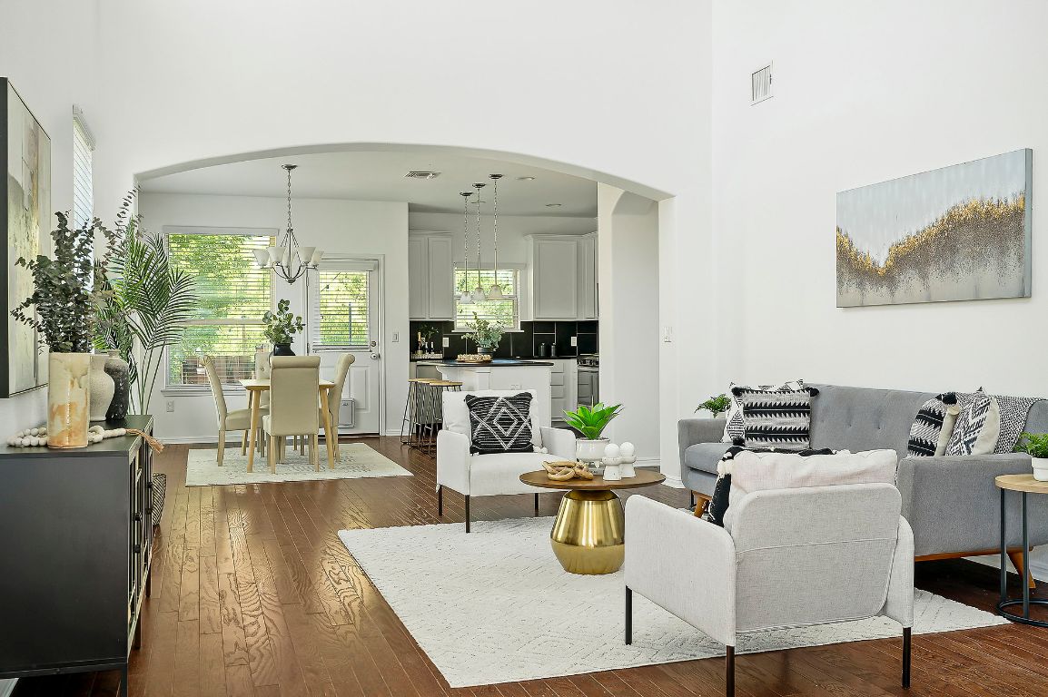 800 Totis Road Austin, TX 78748 - Photo 3 of 29 Living room with dark wood finished floors, a chandelier, arched walkways, and a towering ceiling