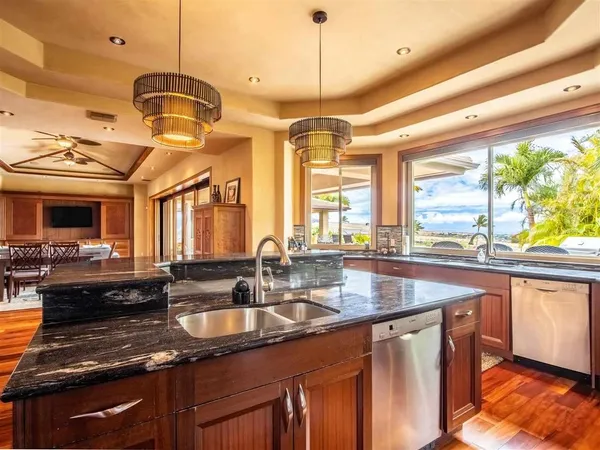 a kitchen with stainless steel appliances granite countertop a sink a stove and a wooden floors
