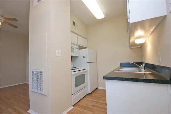 a kitchen with stainless steel appliances granite countertop a sink and a refrigerator