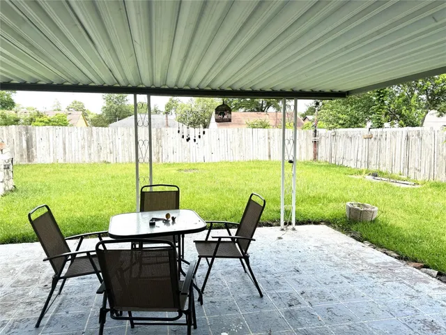 a view of a patio with table and chairs under an umbrella