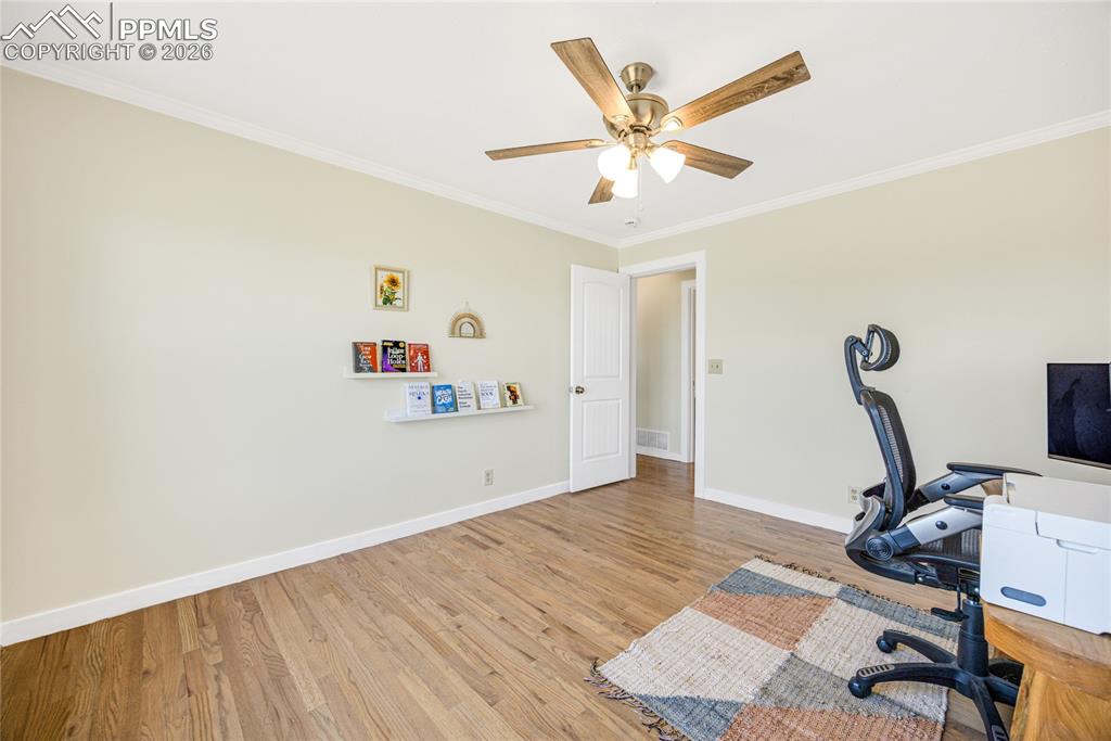 17520 Fremont Fort Road Peyton, CO 80831 - Photo 20 of 42 This room features hardwood flooring, light-colored walls, and a ceiling fan with integrated lighting