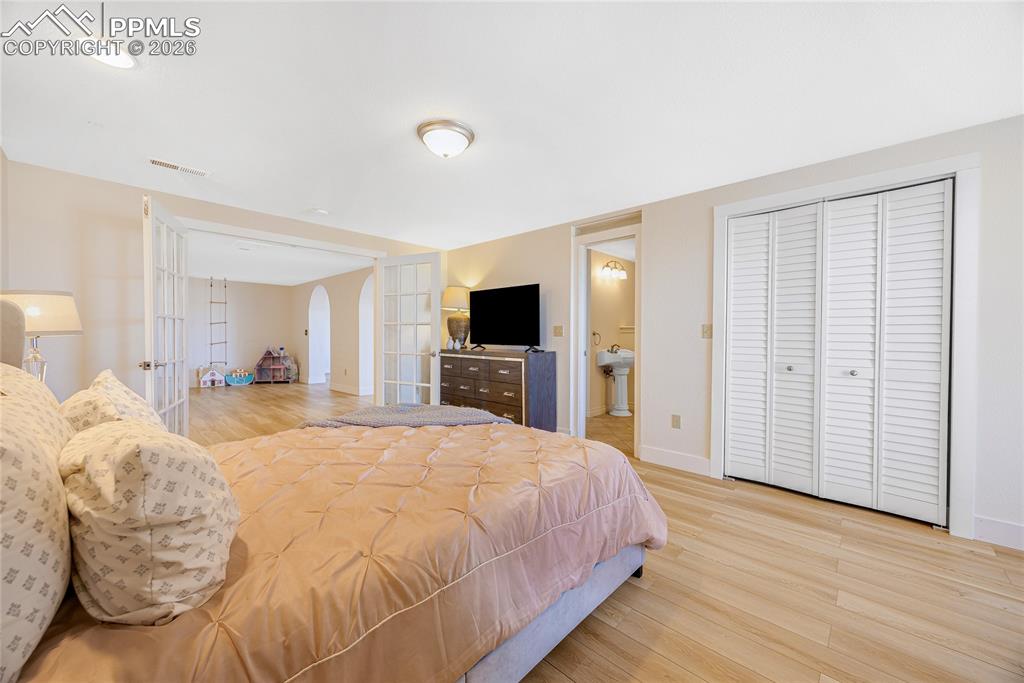 17520 Fremont Fort Road Peyton, CO 80831 - Photo 30 of 42 The room features light-colored walls, light wood flooring, and white bi-fold louvered closet doors