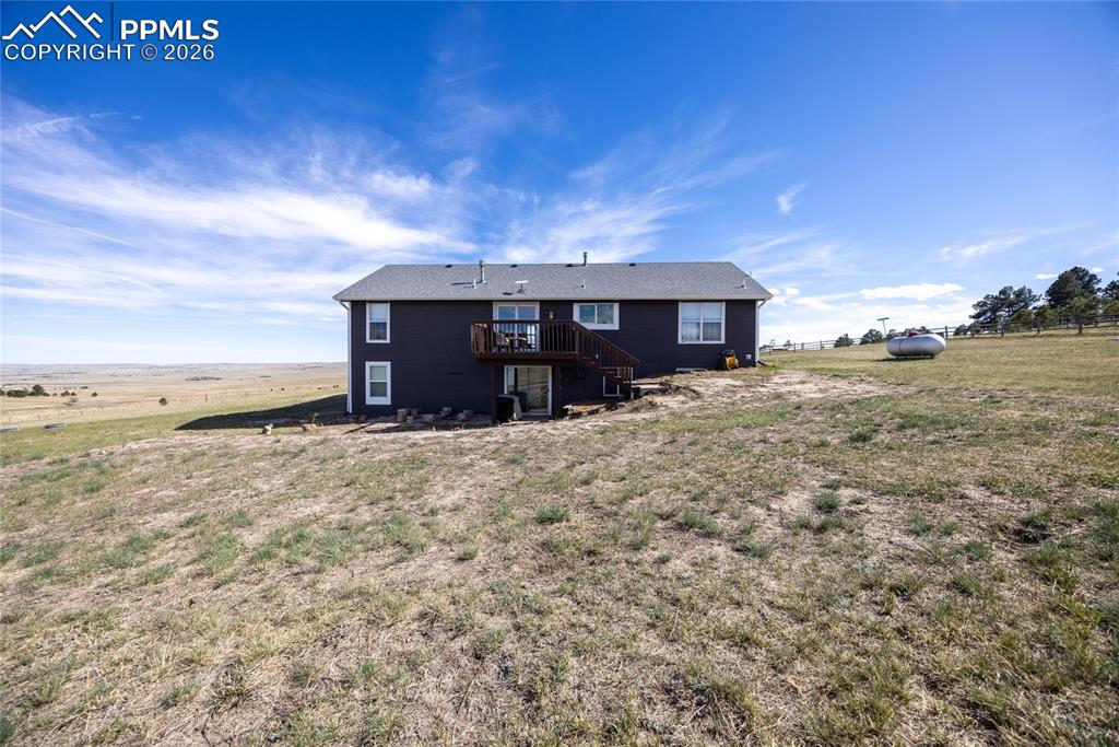 17520 Fremont Fort Road Peyton, CO 80831 - Photo 34 of 42 The property features an exterior with dark siding, a deck, and a walk-out lower level with concrete and paver patios