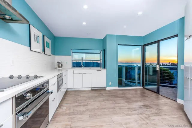 a large white kitchen with a large window
