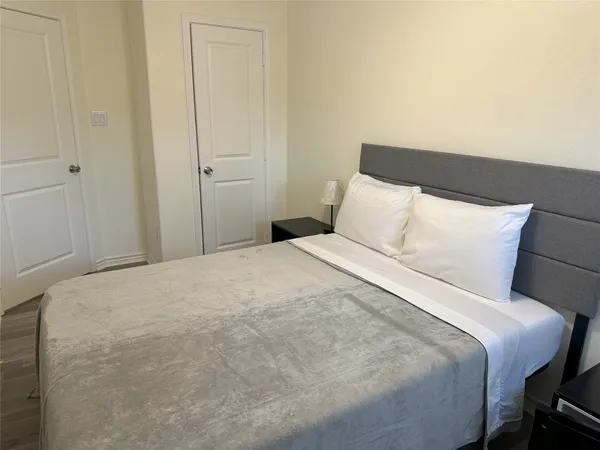 an empty room with wooden floor and hallway
