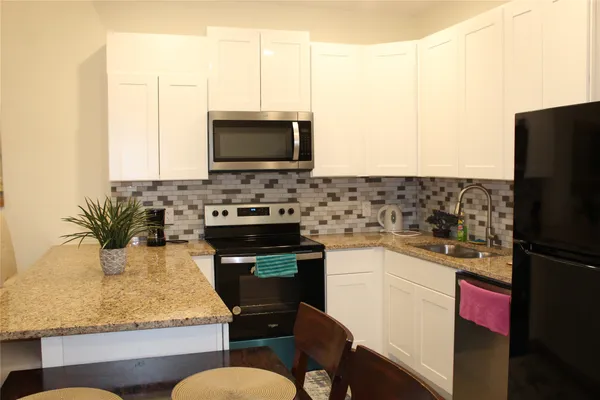 a kitchen with sink a microwave a stove and refrigerator