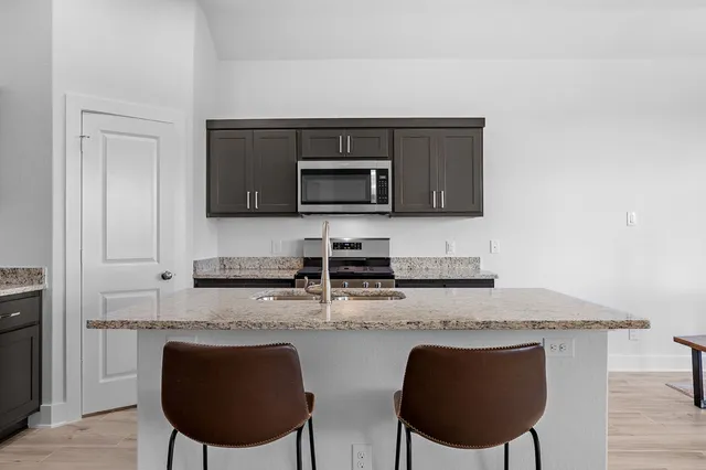 a kitchen with stainless steel appliances granite countertop a stove a sink dishwasher and a microwave