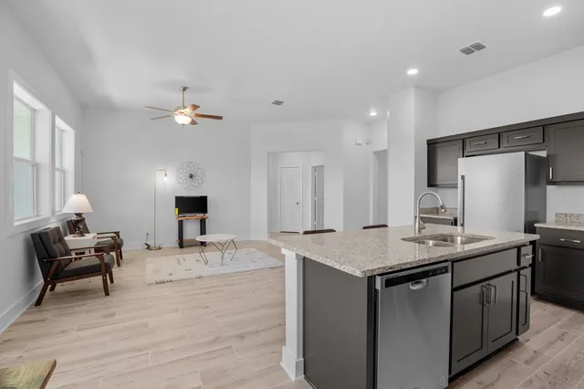 a kitchen with stainless steel appliances granite countertop a sink a stove and a refrigerator