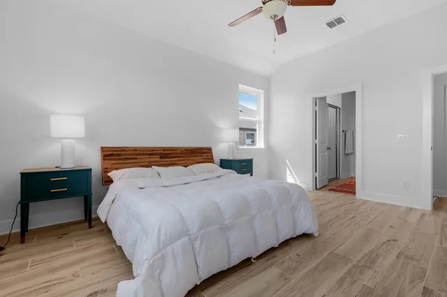 a bedroom with bed and wooden floor