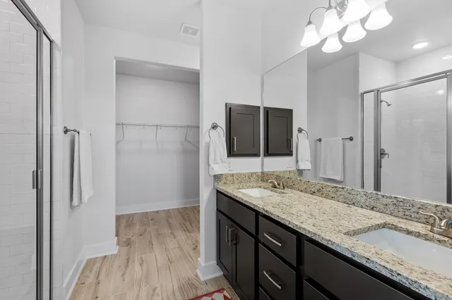 a bathroom with a granite countertop sink a large mirror and a shower