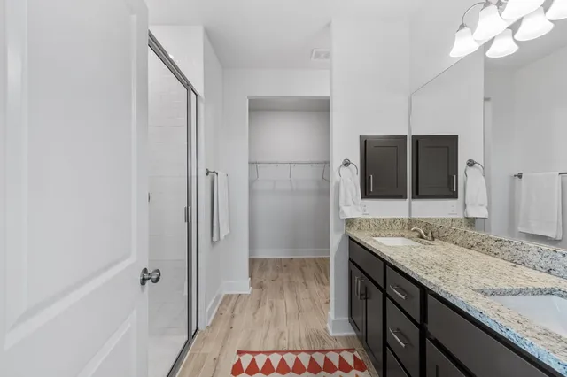 a bathroom with a granite countertop sink a mirror and shower