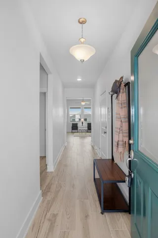 a view of a hallway with wooden floor and a chandelier