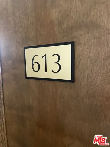 a view of a refrigerator in kitchen and an empty room