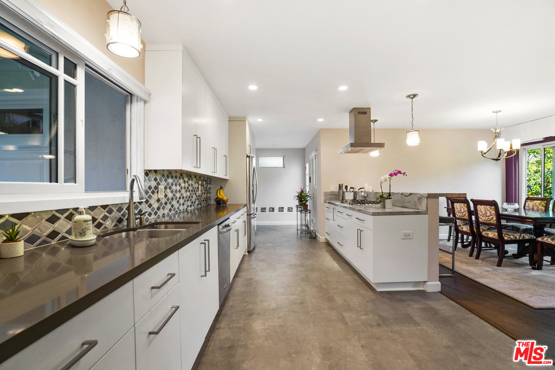 910 Hillcroft Road Glendale, CA 91207 - Photo 12 of 37 a large kitchen with kitchen island a large island a sink and white cabinets