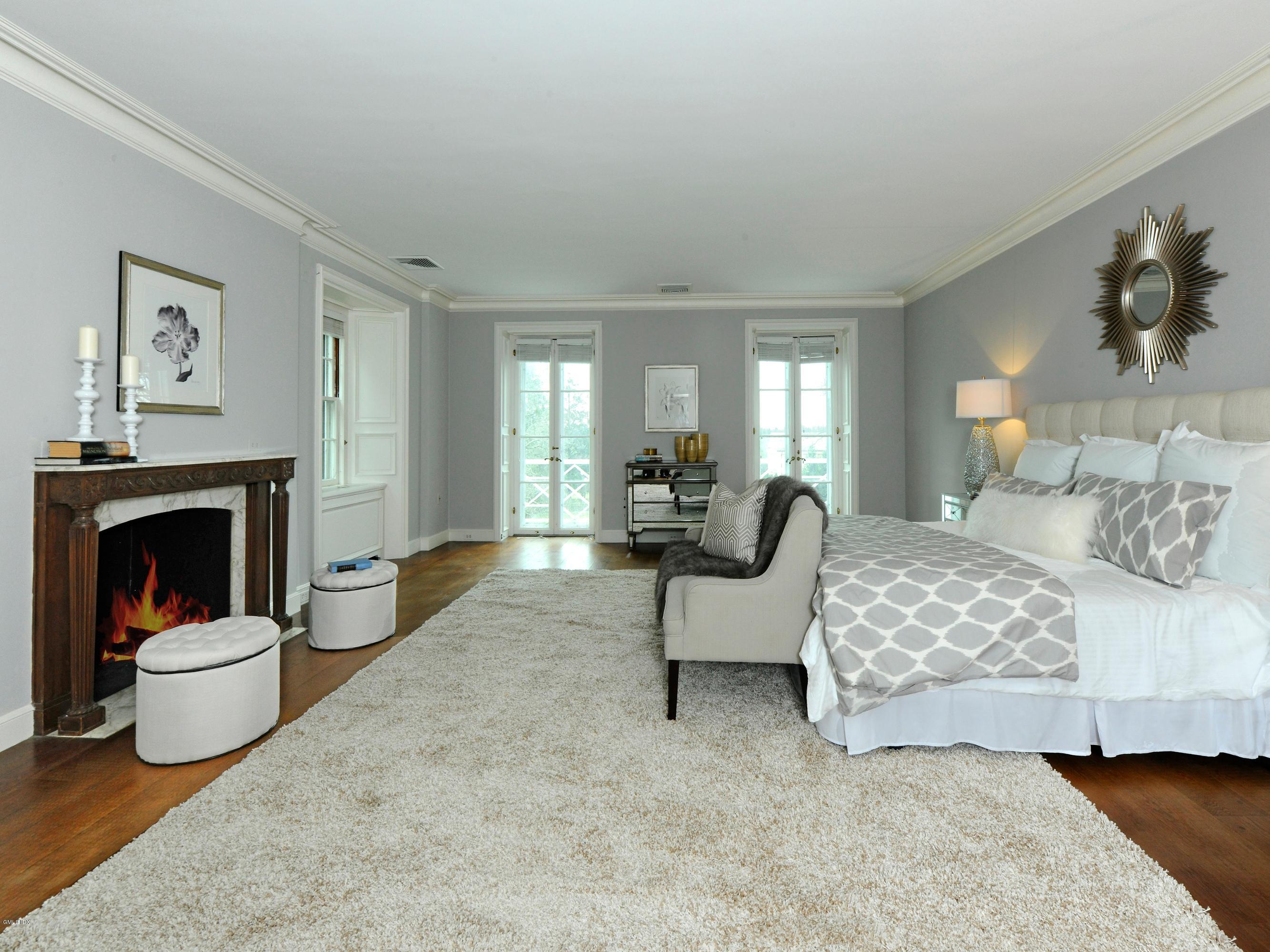 141 Taconic Road Greenwich, CT 06831 - Photo 13 of 30 a bedroom with a bed and a fireplace