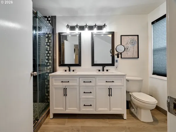 a bathroom with a double vanity sink mirror and shower