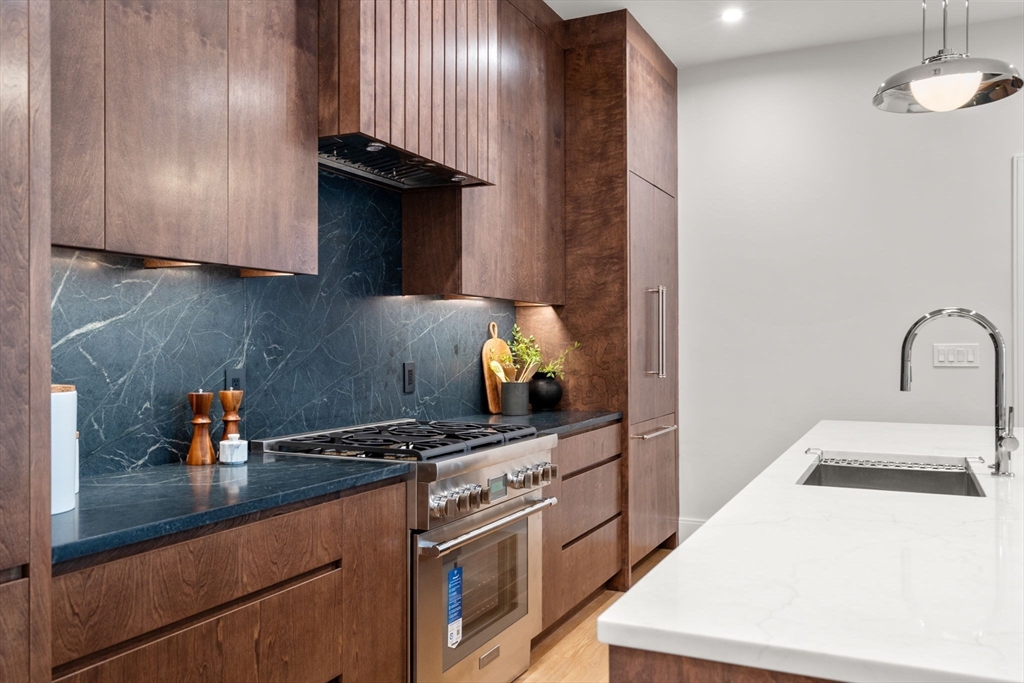 67 Church Street, Unit 1 Boston, MA 02116 - Photo 8 of 15 a kitchen with stainless steel appliances granite countertop a sink stove and cabinets